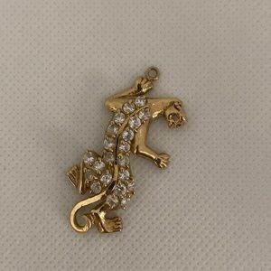 10 karat yellow gold panther/jaguar pendant with 21 white simulated stones. ASK.